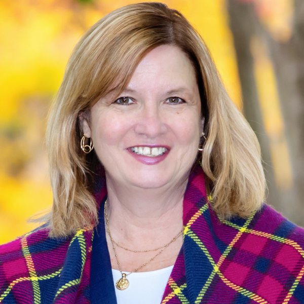 Woman with blonde hair in plaid jacket